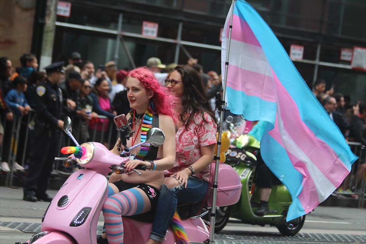 Dos mujeres portan la bandera transexual