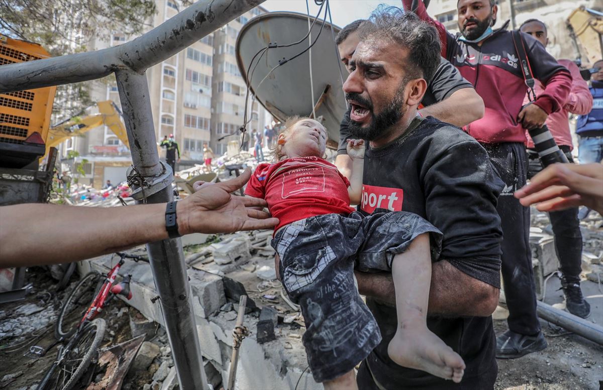 Un palestino lleva el cuerpo sin vida de su hija tras sacarlo de entre los escombros en Gaza