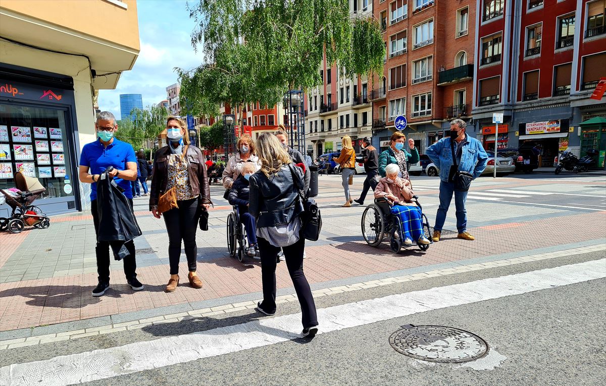 Varias personas en Bilbao esperando para cruzar un paso de cebra