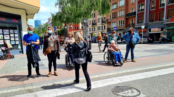 Varias personas en Bilbao esperando para cruzar un paso de cebra