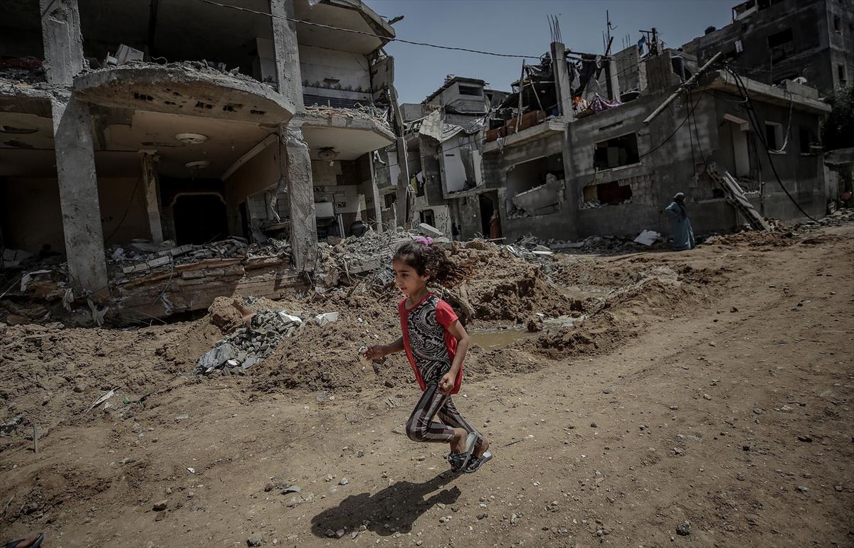 Una niña corre entre los escombros en Gaza.