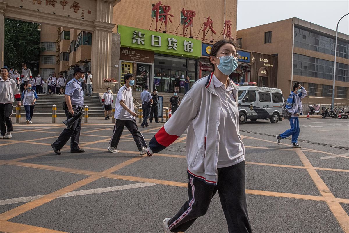 Varios estudiantes con máscaras protectoras saliendo de una escuela en Pekín