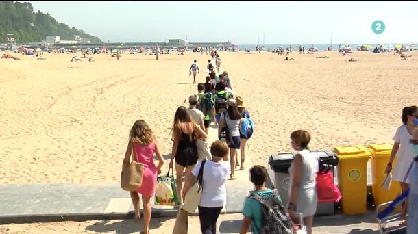 Bañistas entrando a la playa de Deba