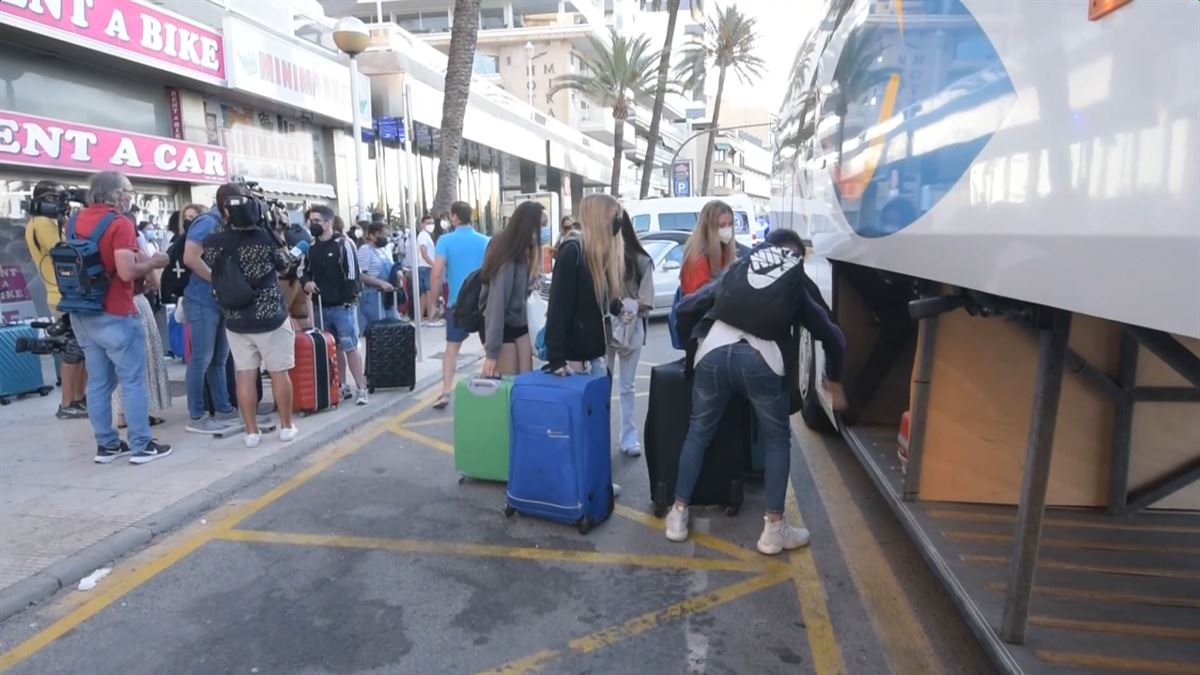 Estudiantes meten las maletas en el autobús