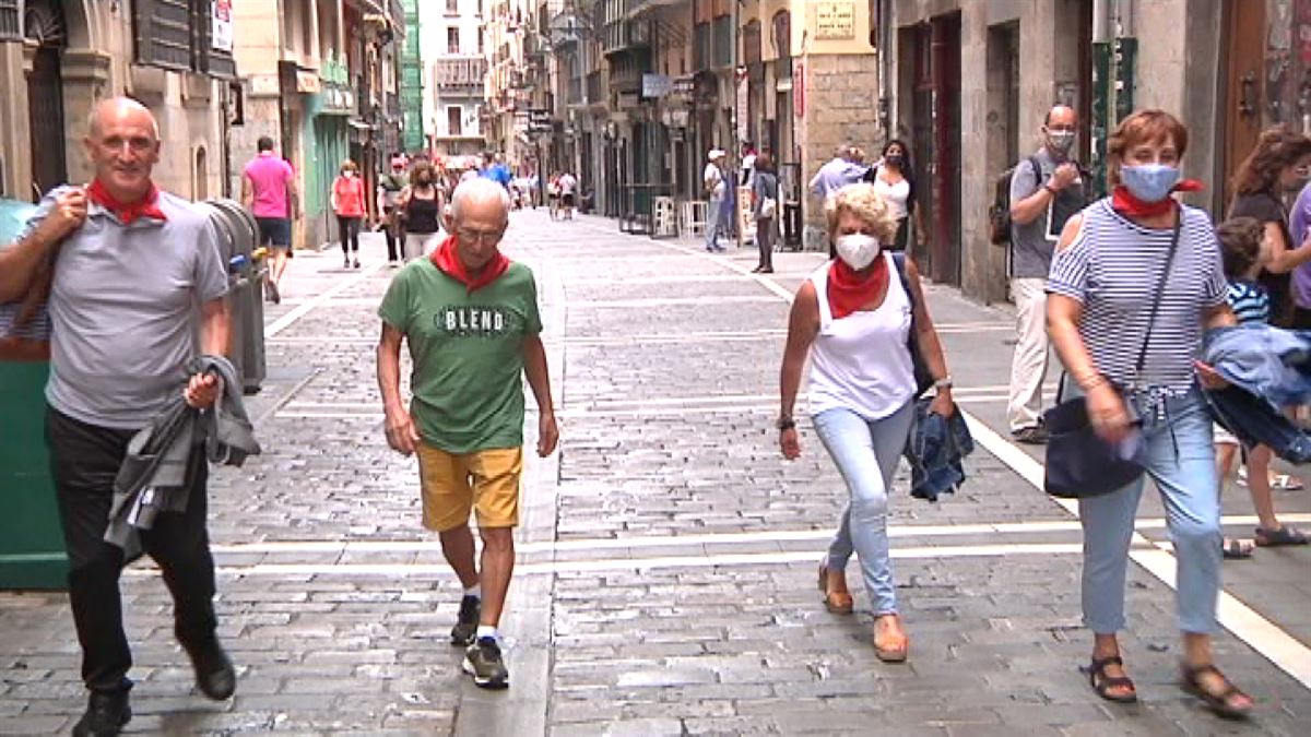 Varias personas pasean con el "pañuelico" por Pamplona