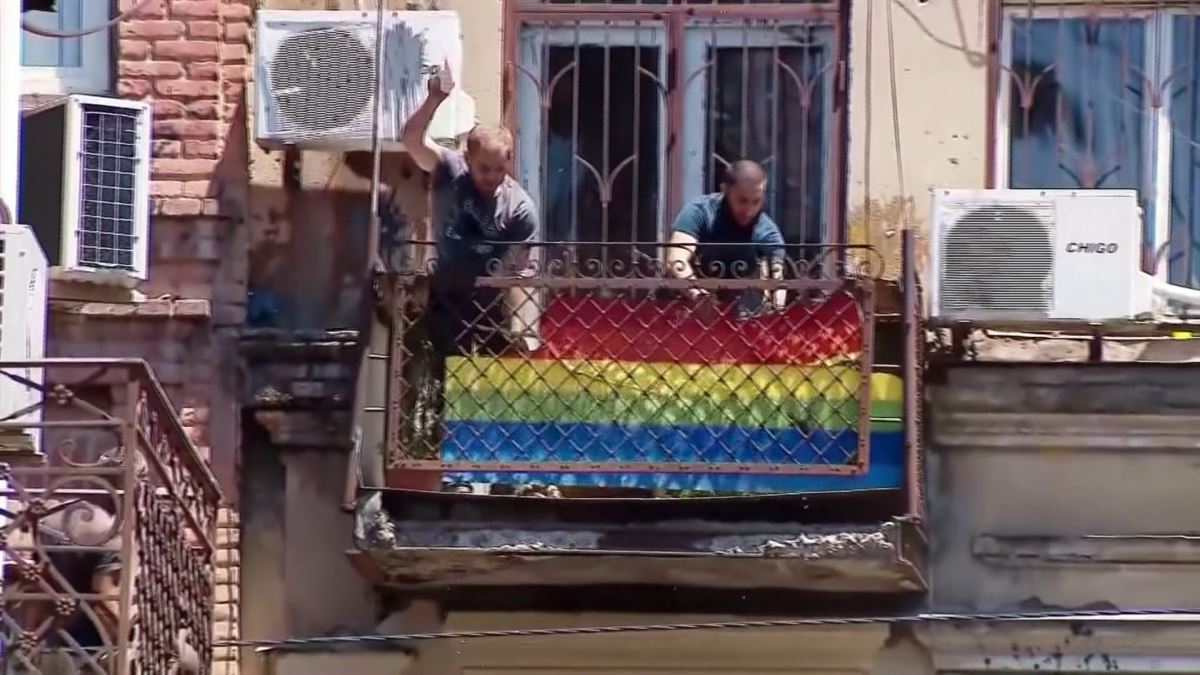 Manifestantes arrancan una bandera arcoiris