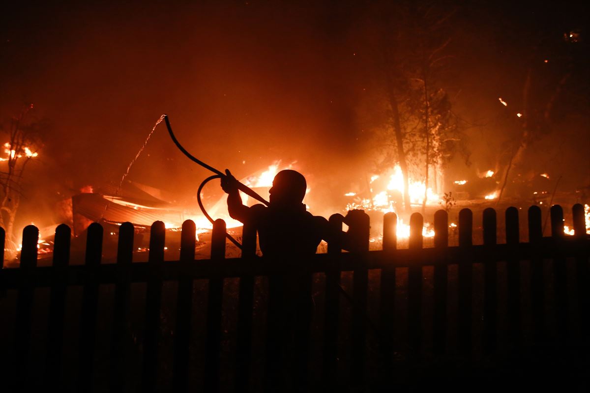 Un vecino de Atenas intenta luchar contra las llamas. 