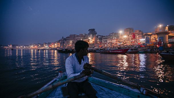 Indiako Varanasi hiria zeharkatzen duen Ganges ibaian gizonezko bat txalupa batean