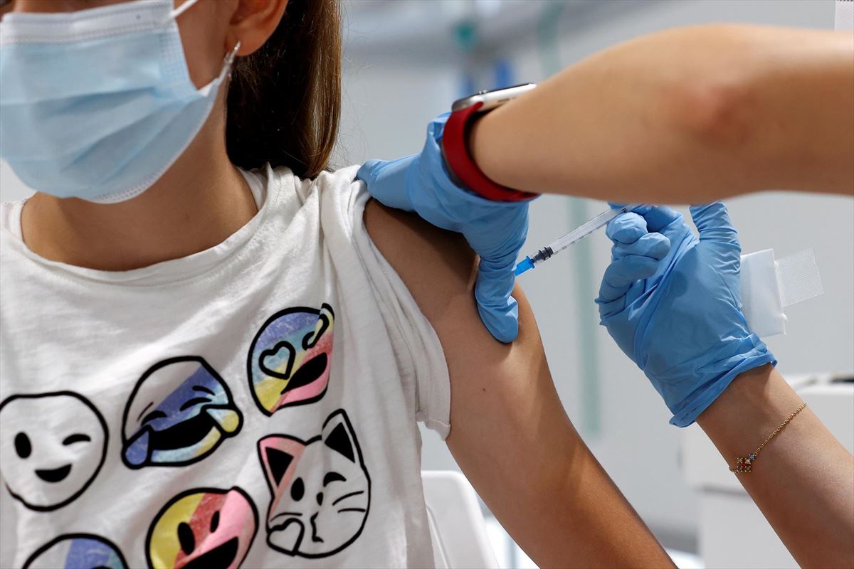 Una joven recibe una vacuna contra el coronavirus. Foto: EFE.