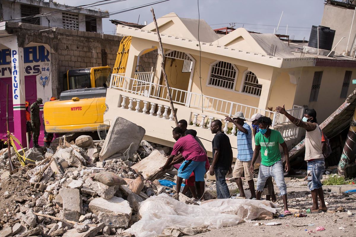 Varias personas buscan a supervivientes del sismo de Haití. Foto: EFE