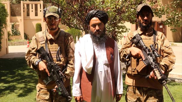 El portavoz de los talibanes, Zabiullah Mujahid, escoltado por dos militares. Foto: EFE 