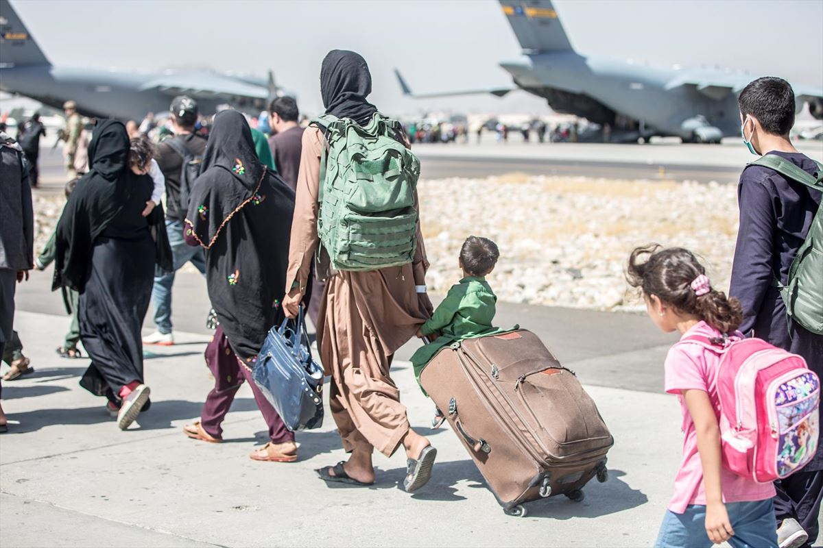 Un grupo de afganos, entre ellos dos menores, se dirigen a un avión en el aeropuerto de Kabul. EFE