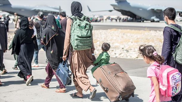 Un grupo de afganos, entre ellos dos menores, se dirigen a un avión en el aeropuerto de Kabul. EFE