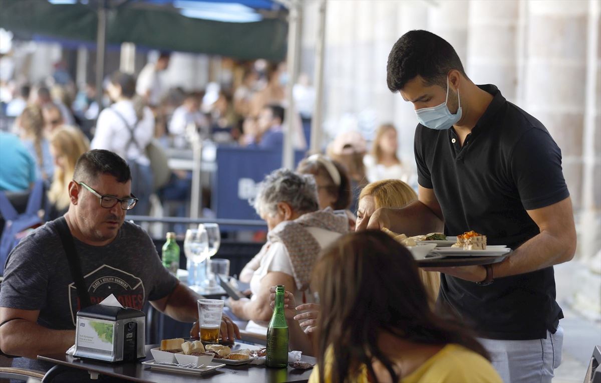 Un camarero sirve a los clientes en la terraza de un bar. EFE
