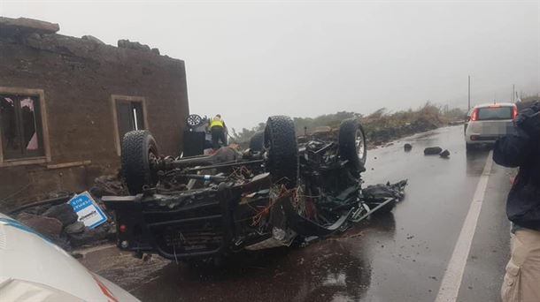 Un coche volcado y un edificio sin tejado