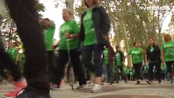 Varias Personas andando con la camiseta verde de la marcha.