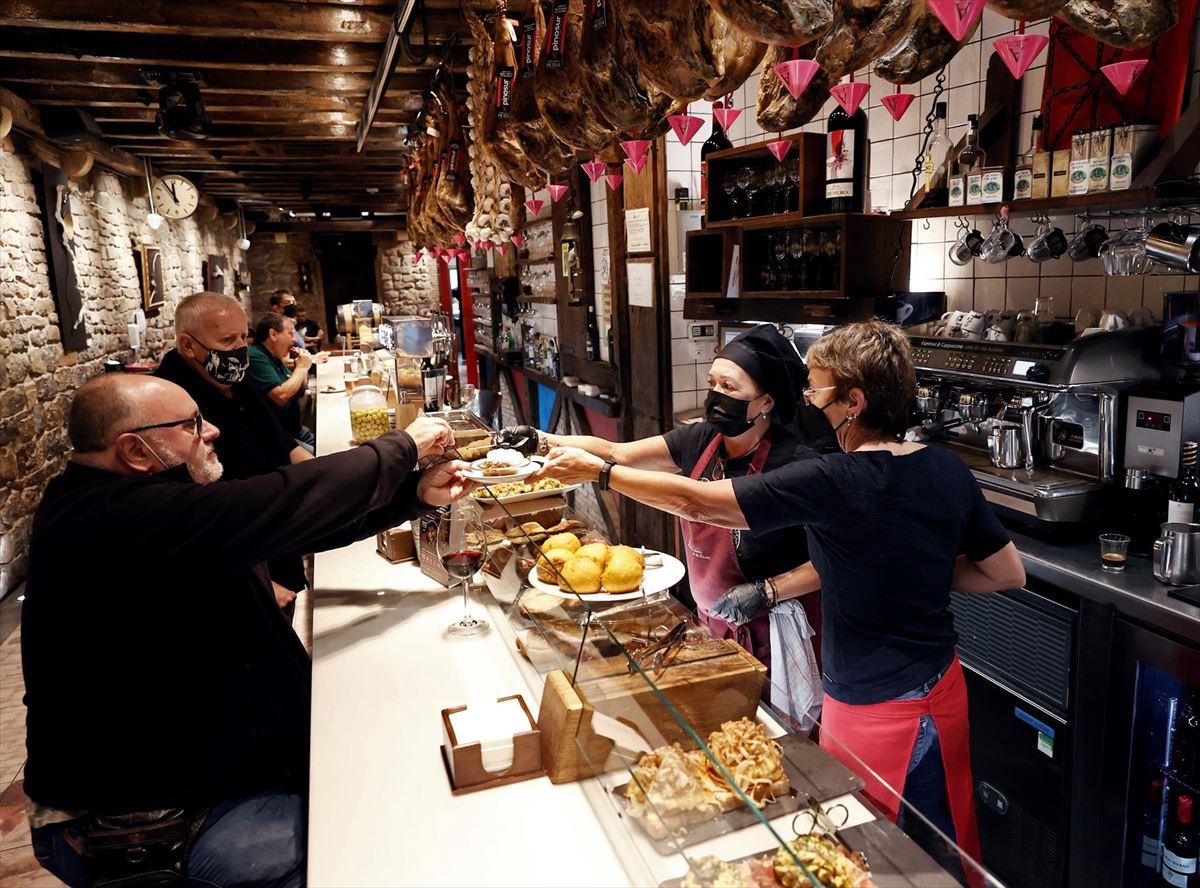 Clientes consumiendo en el interior de un bar en Pamplona