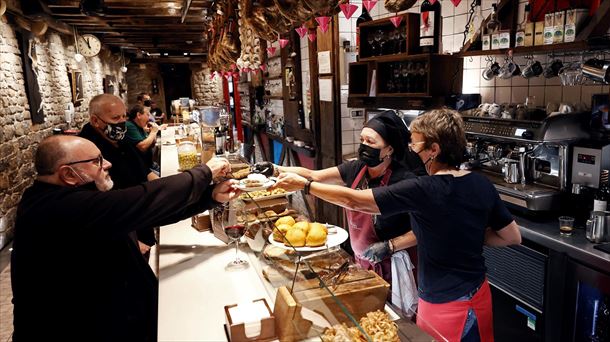 Clientes consumiendo en el interior de un bar en Pamplona