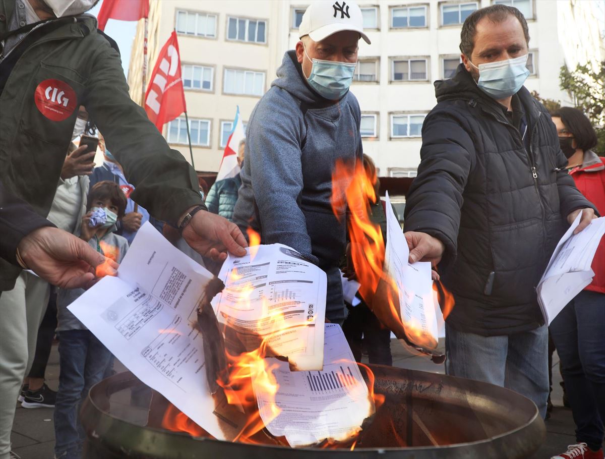 Un grupo de personas quema sus facturas eléctricas el domingo en Santiago de Compostela. Foto: EFE