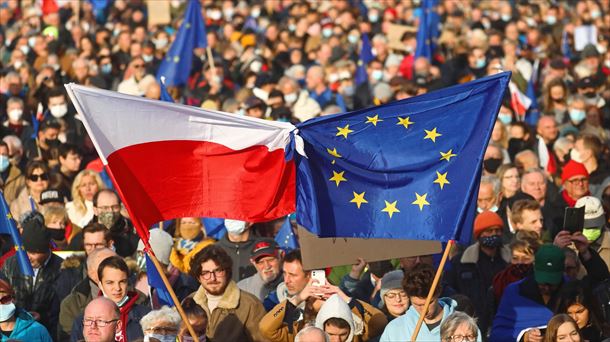 Las personas portan banderas polacas y de la UE durante una protesta en Cracovia, Polonia