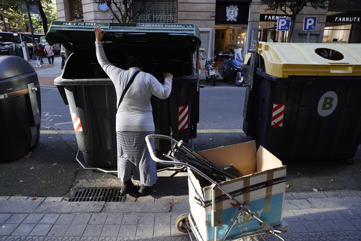 Una mujer busca chatarra en Bilbao. Foto: EFE