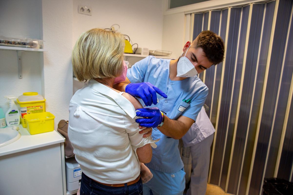Un enfermero vacuna a una mujer.