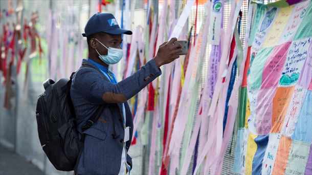 Un hombre fotografía el mural de mensajes en el exterior del recinto del COP26. 