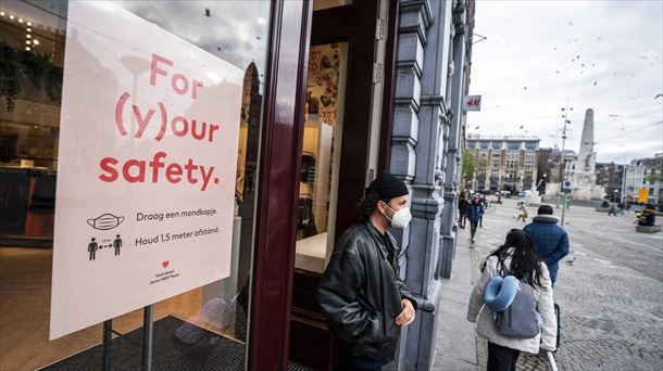 Un hombre con la mascarilla puesta saliendo de una tiena en Amsterdam. Foto: EFE