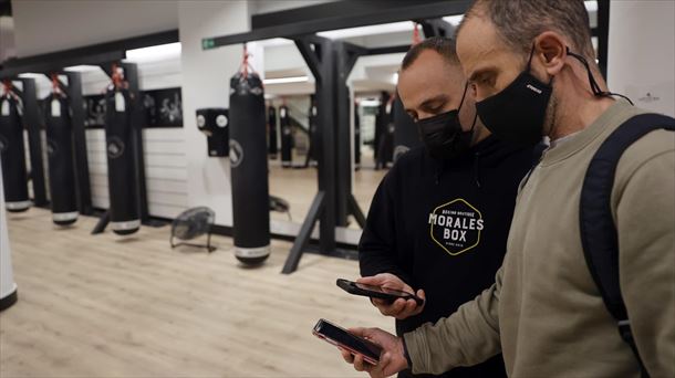 Bilboko gimnasio bateko langilea, covid pasaporte bat eskaneatzen. Argazkia: EFE 