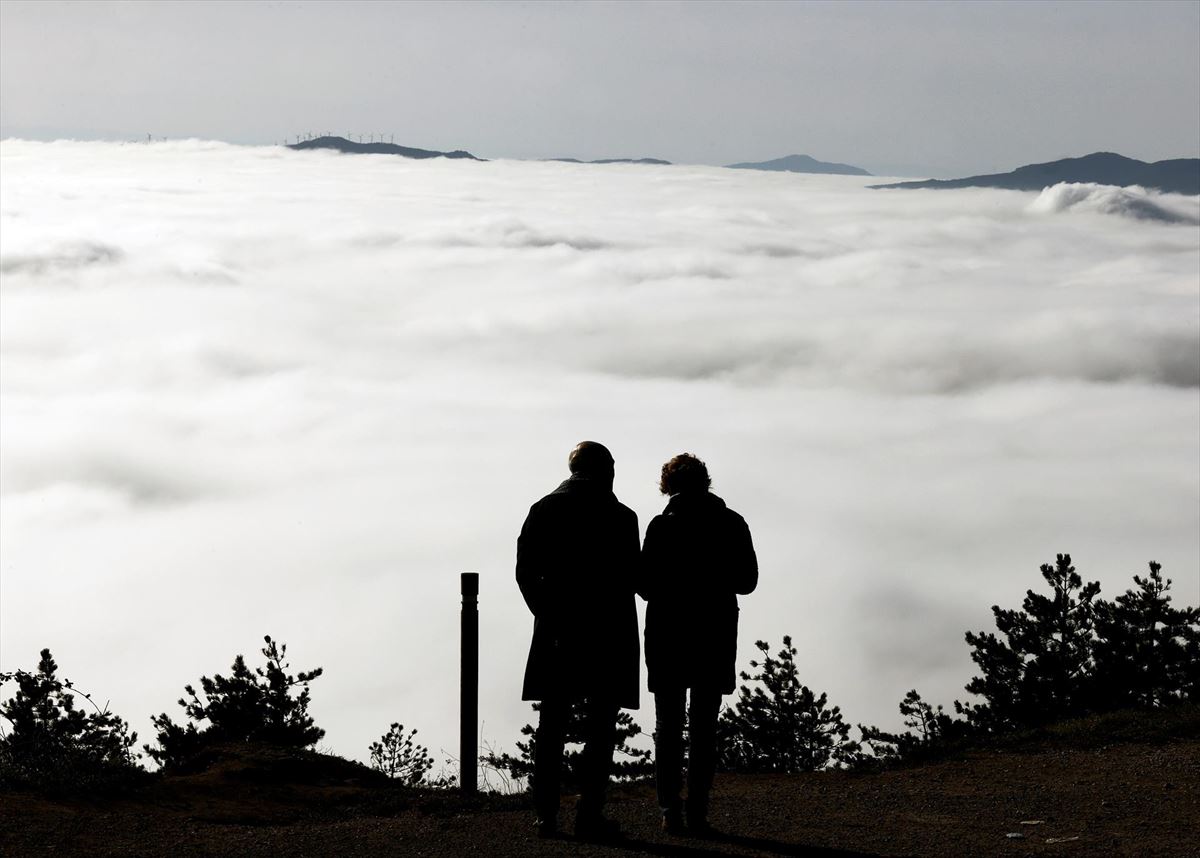 Dos personas, en el Alto de San Cristobal entre nieblas. 