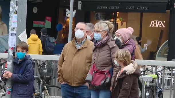 Personas con mascarilla esperan a cruzar la calle.