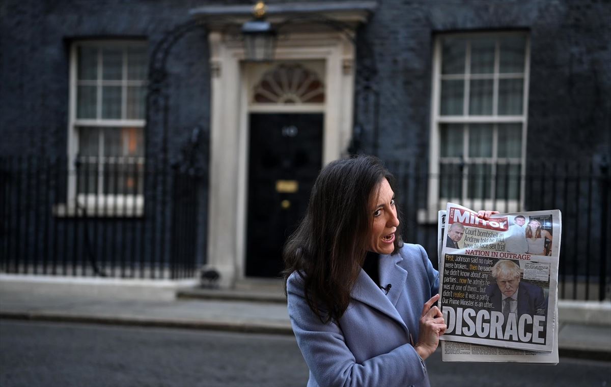 Una periodista muestra un portada sobre la pólemica que rodea a Boris Johnson en Downing Street. EFE