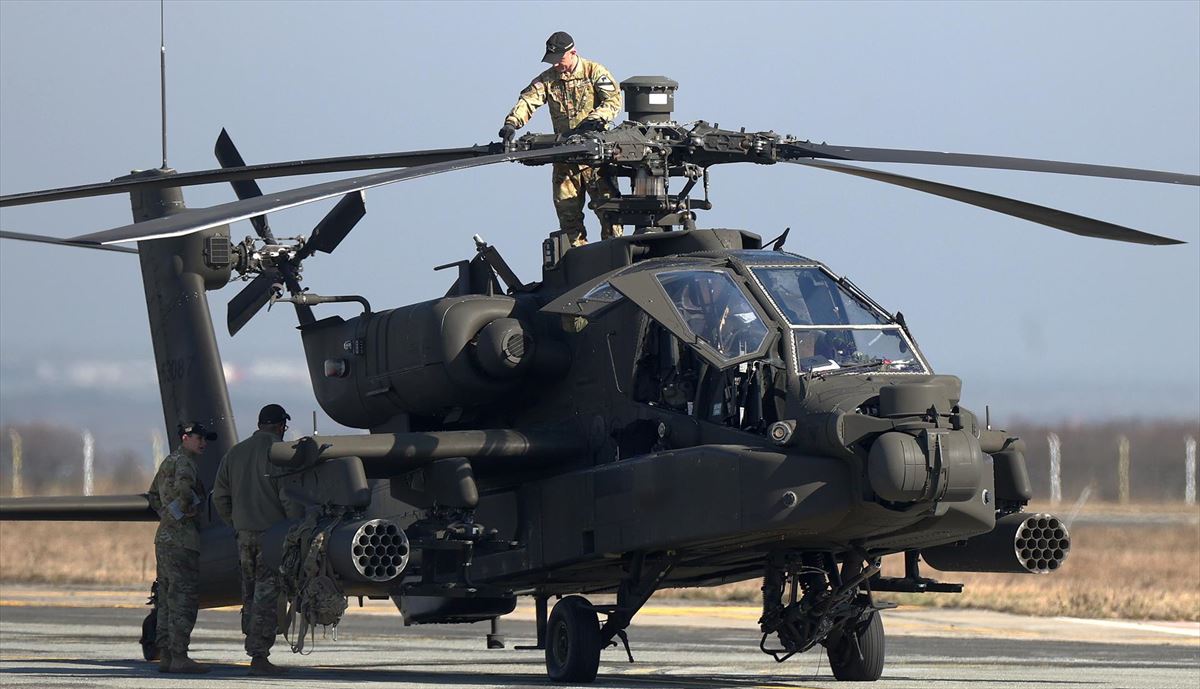 Personal militar estadounidense realiza verificación antes del despegue de un helicóptero de ataque