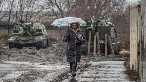 Una mujer camina frente a blindados rusos en la estación de Rostov. Foto: Yuri Kochetkov - EFE