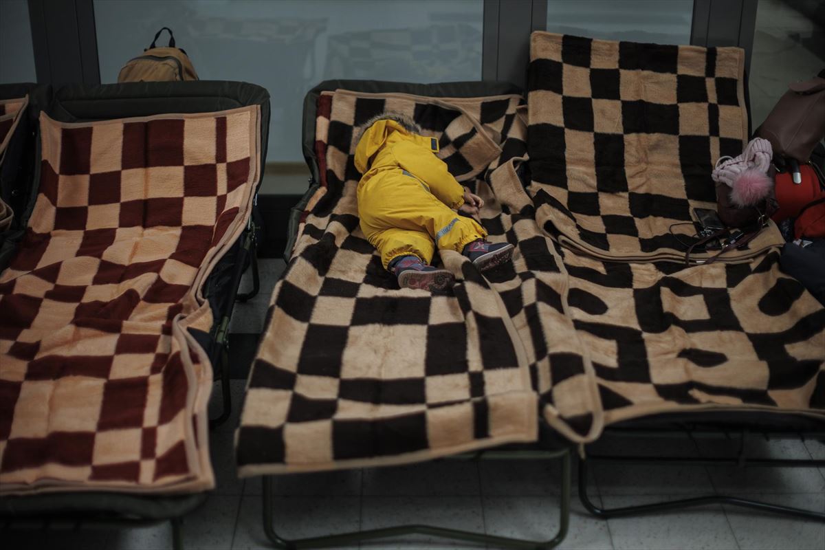 Niño ucraniano duerme en un centro comercial de Polonia. Foto: EFE.