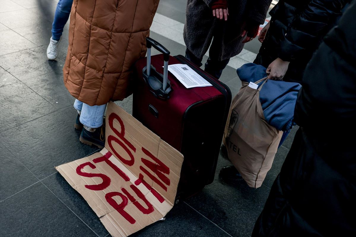 En un cartón se lee "Stop Putin", junto al equipaje de un refugiado de Ucrania