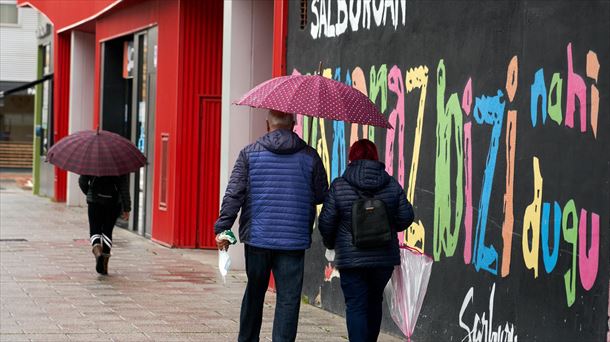 Personas se protegen de la lluvia en el barrio de Salburua en Vitoria-Gasteiz. Foto de archivo: EFE