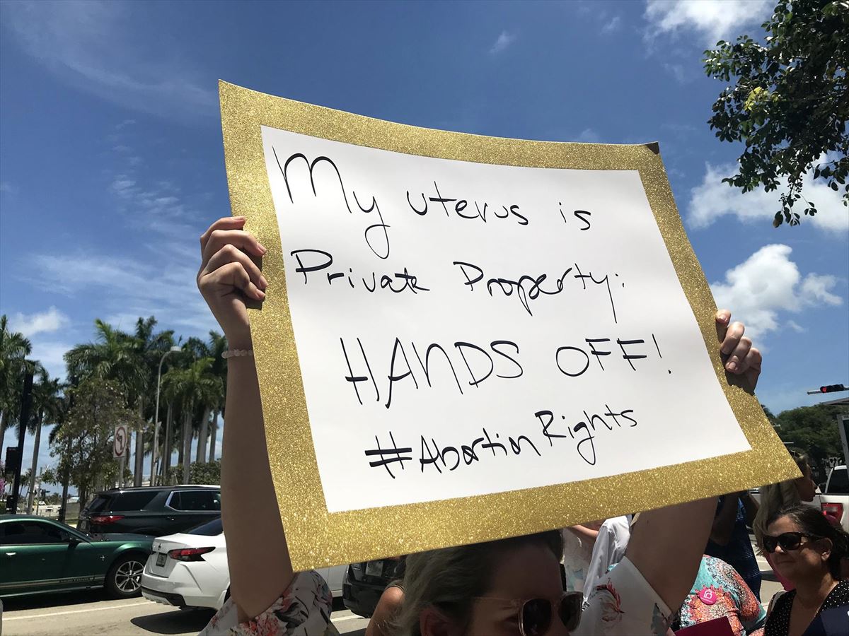 Una mujer sostiene una pancarta que dice "Mi útero es propiedad privada, ¡No lo toques!"
