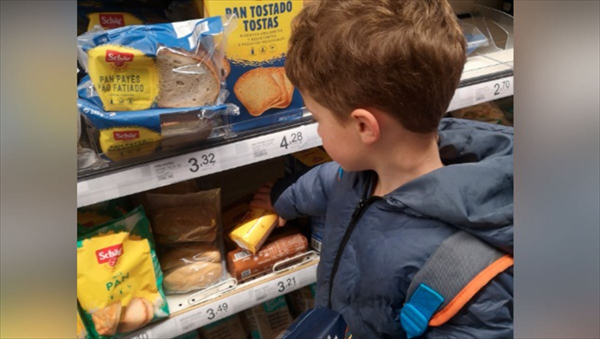 Un niño celíaco escogiendo productos sin gluten en un supermercado