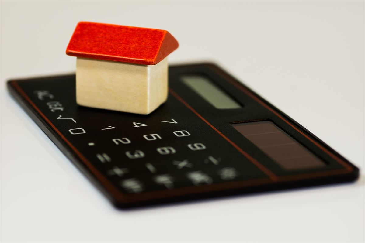 Figura de una casa junto a una calculadora. Imagen libre de derechos de autor