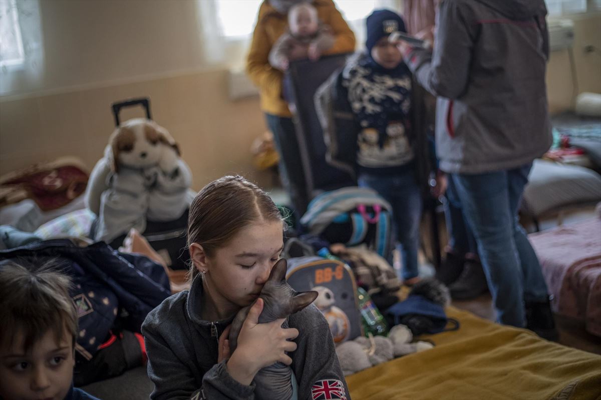 Una niña ucraniana abraza a su gato en un centro para la acogida de refugiados en Eslovaquia. EFE