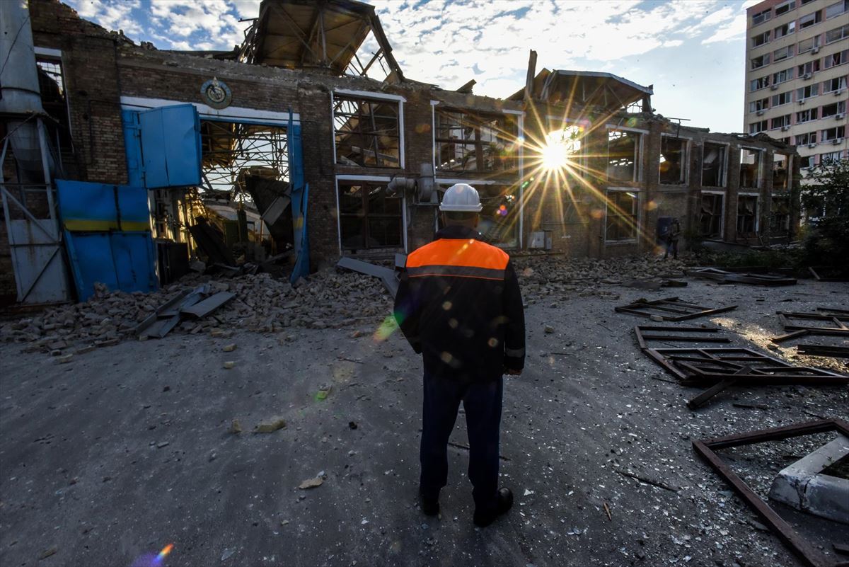 Un trabajador observa un empresa derruida en Kiev.