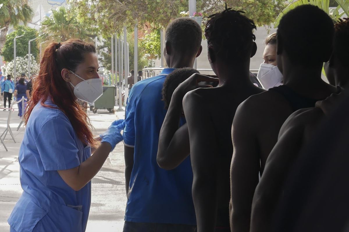 Personas migrantes en Melilla, siendo atendidas por personal sanitario. Foto: EFE