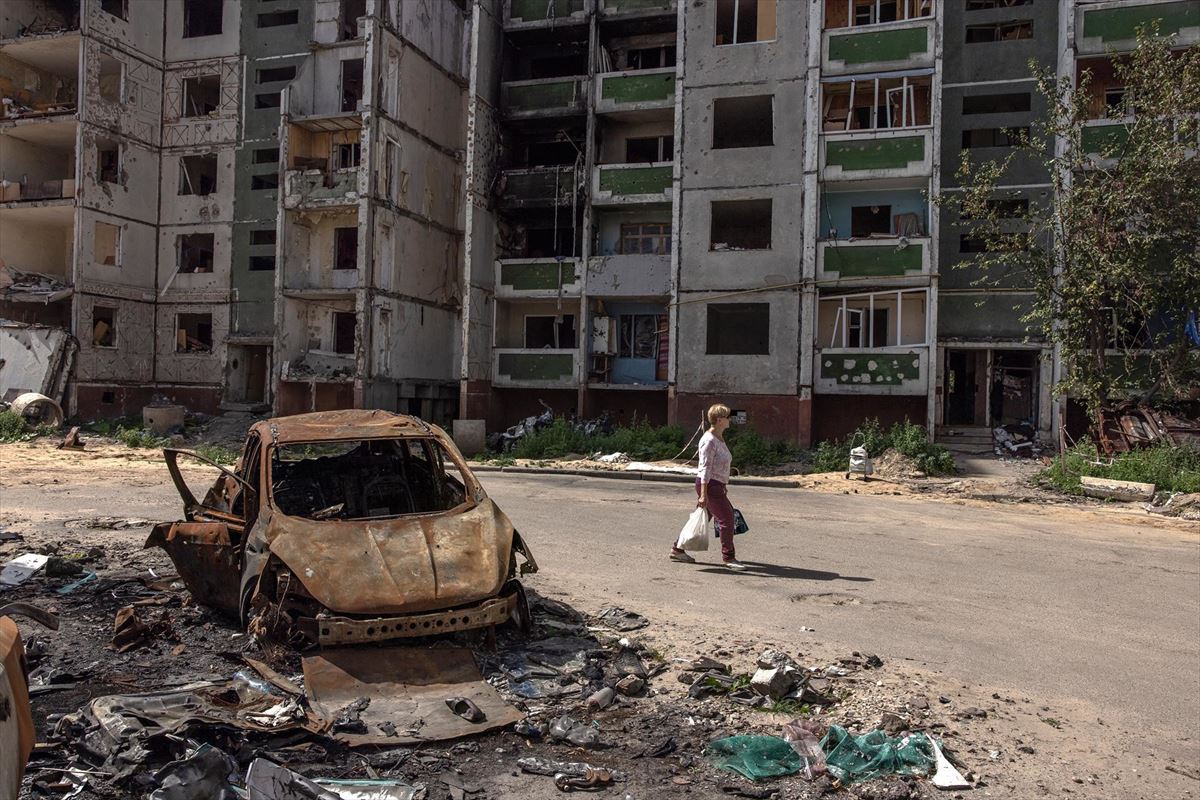 Una mujer camina ante un edificio destruido por las bombas del Armada rusa en Chernihiv. Foto: EFE