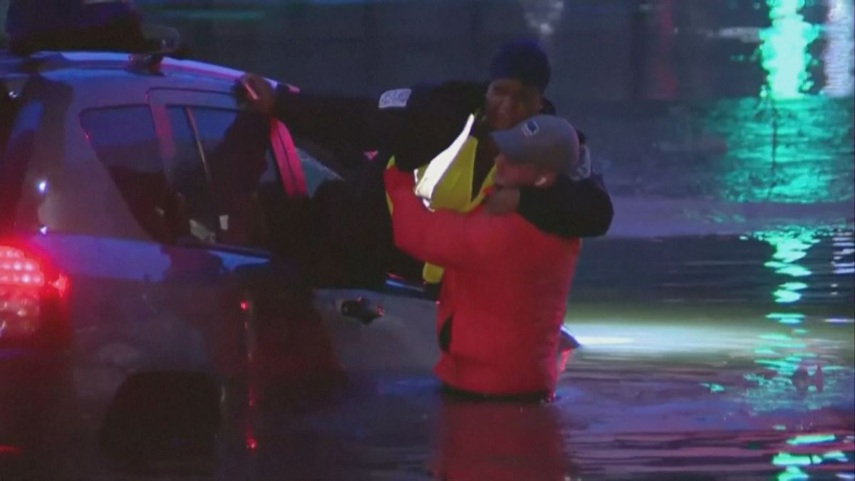 Un hombre saca a una mujer de un coche. Imagen obtenida de un vídeo de Agencias.
