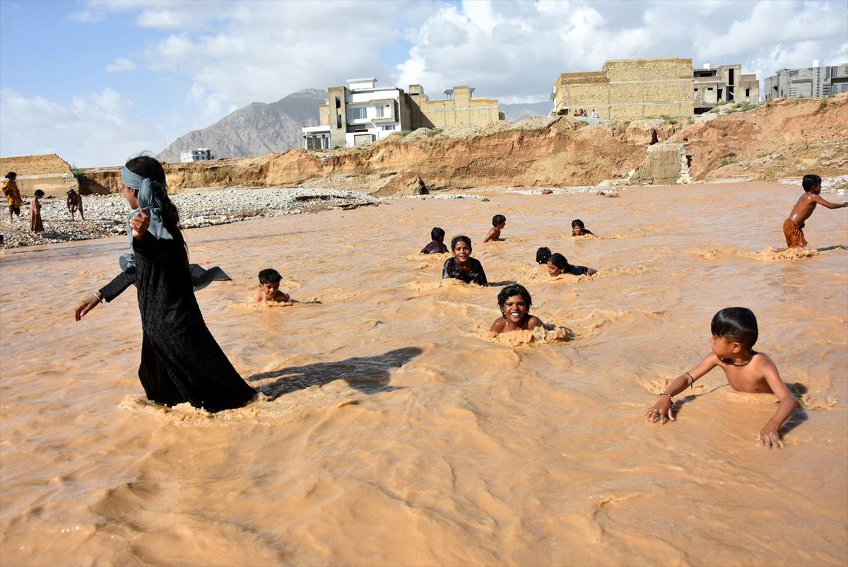 Haurrak uholde arrastoetan bainua hartzen Quettan, Pakistanen. Argazkia: EFE