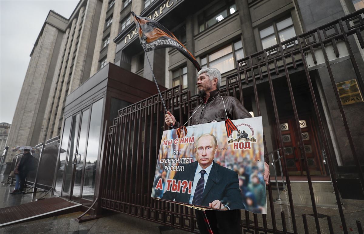 Un hombre sostiene una pancarta frente al edificio de la Duma Estatal Rusa en Moscú.