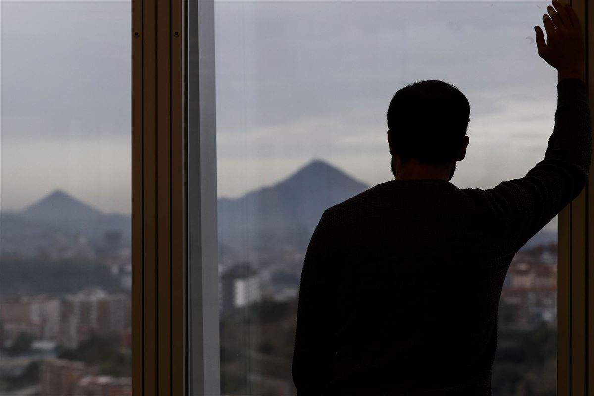 Un hombre mirando por una ventana