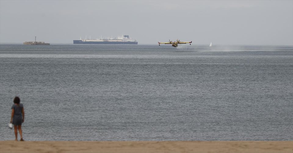 Un avión anfibio cargando agua en la playa de Ereaga. Foto: EFE
