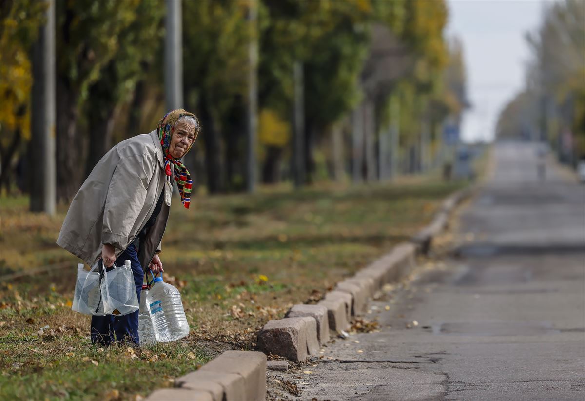 Una anciana lleva agua potable en Mykolaiv, Ucrania. Foto: EFE